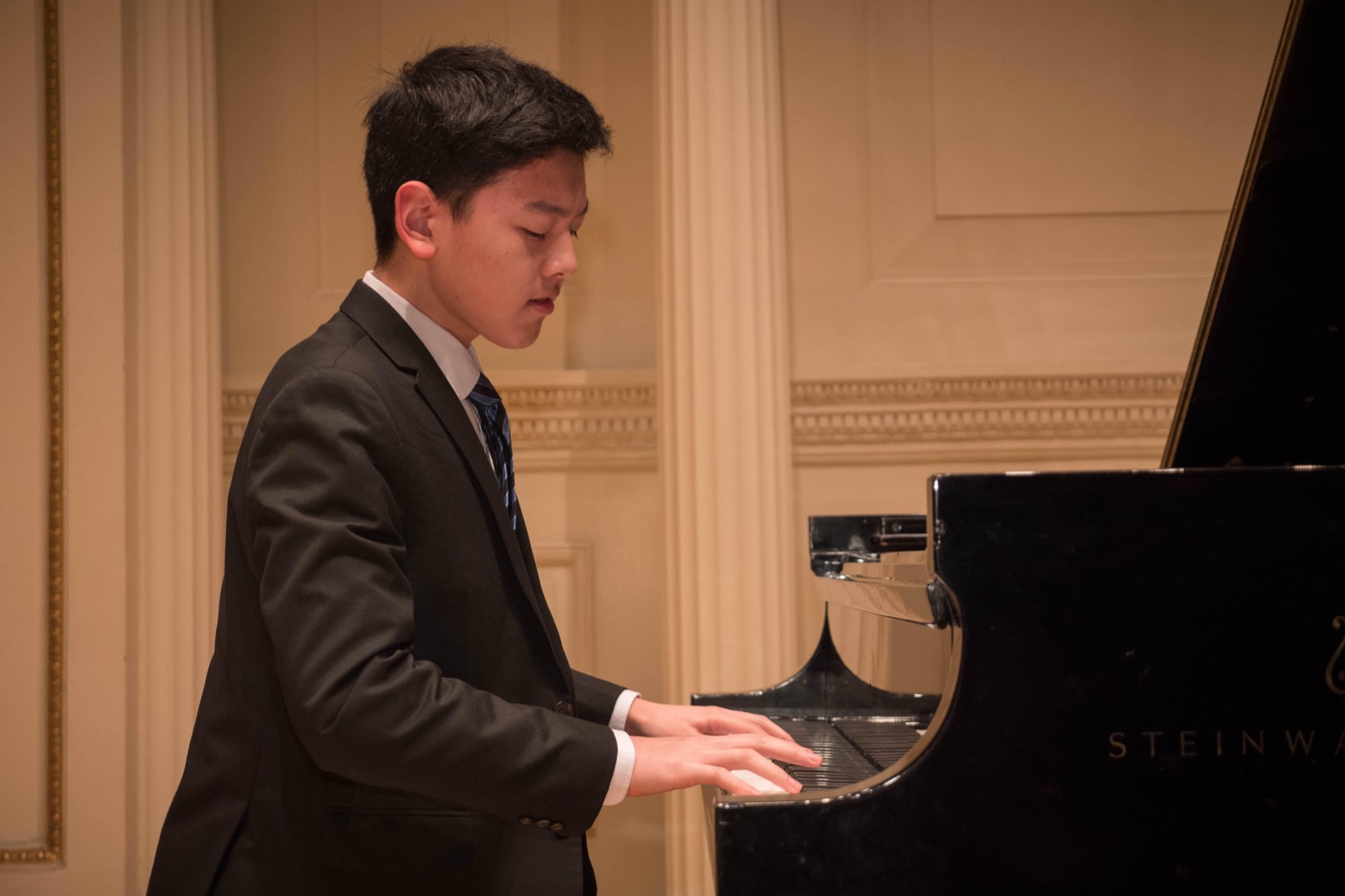 Both hands on the keys, head lowered